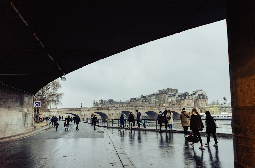 people walking on gray concrete pavement near city buildings during daytime