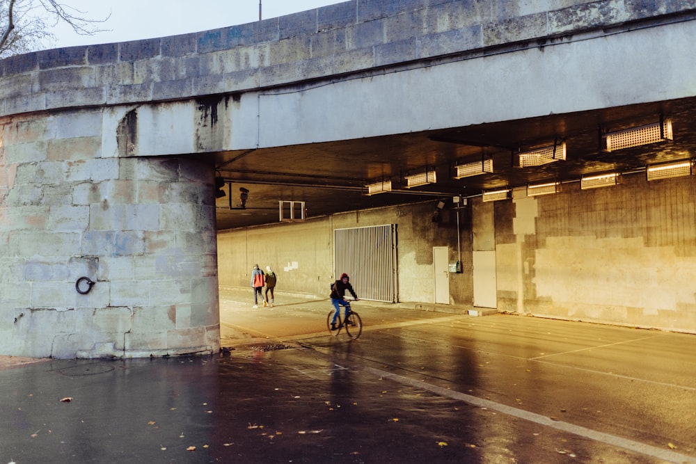 man in black jacket riding bicycle on road during daytime