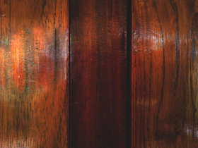 Close-up of a sleek wood-grain laminate panel with rich texture and warm tones