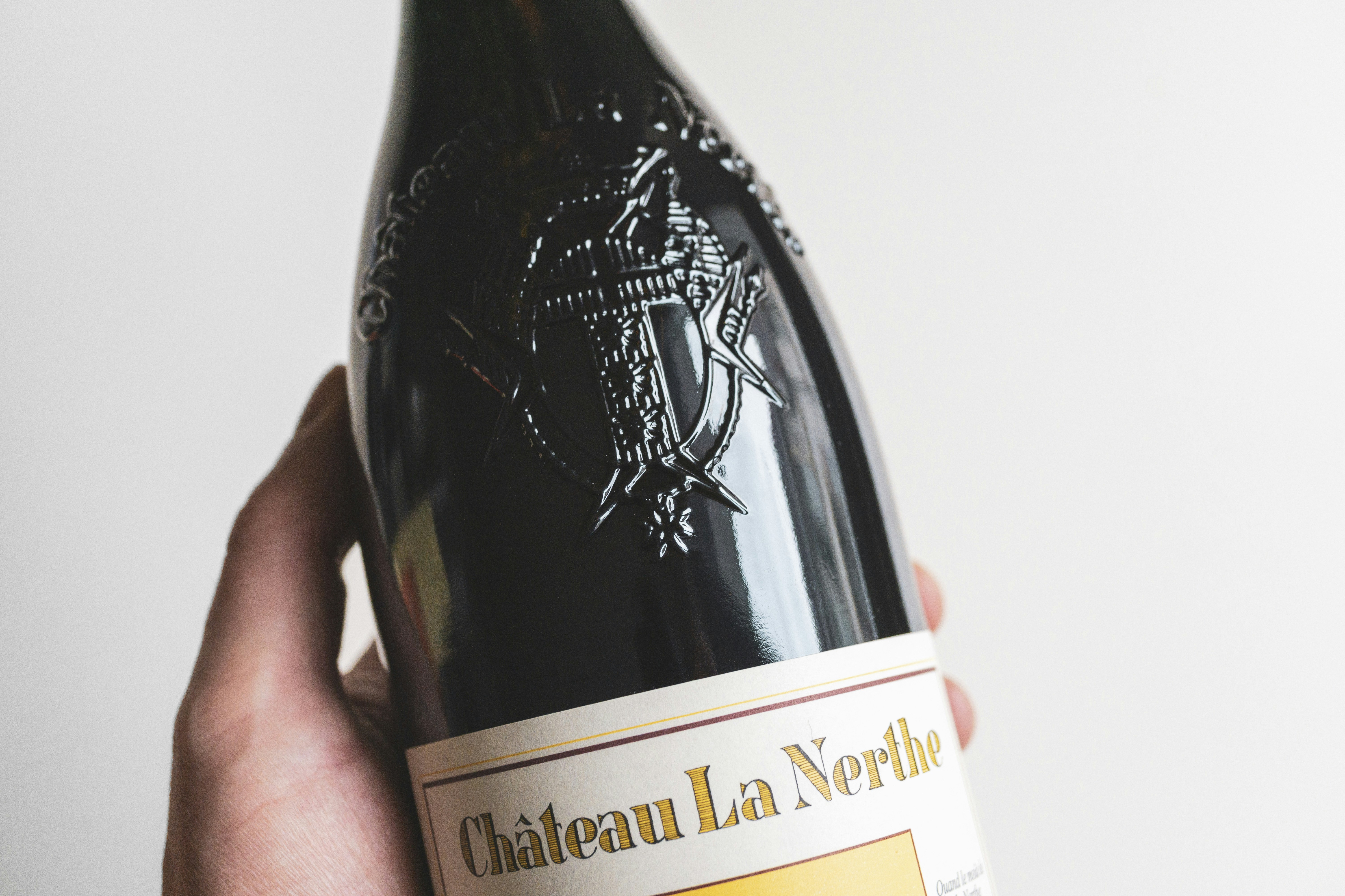 a person holding a bottle of wine in their hand