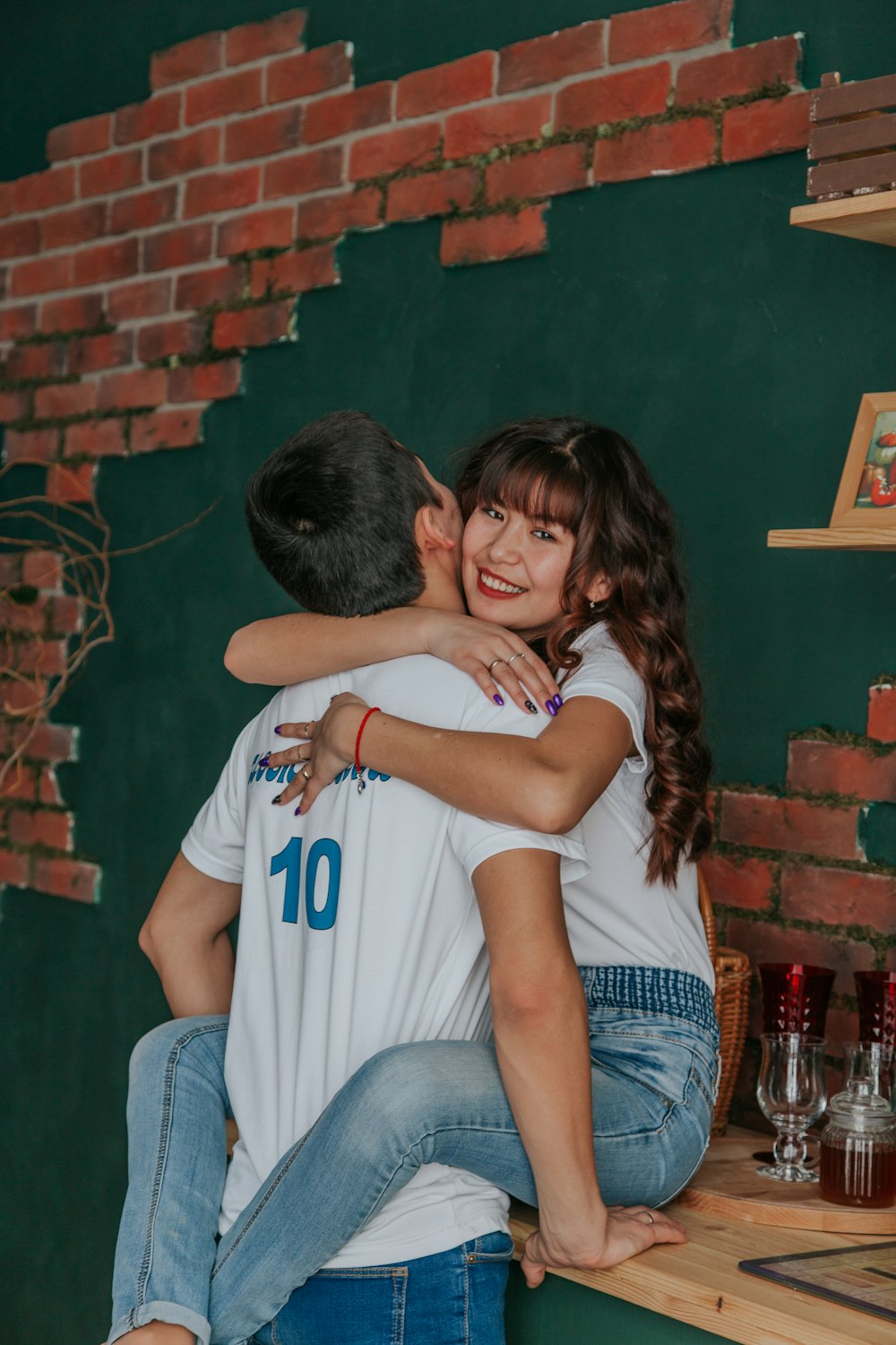 man in gray t-shirt kissing woman in blue t-shirt