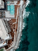 Aerial shot of a luxury property complex near the sparkling ocean coastline