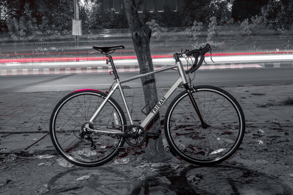 red and black road bike parked beside road