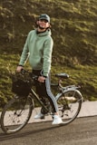 A laid-back dad wearing a funny cycling shirt, laughing with friends at a casual outdoor gathering.
