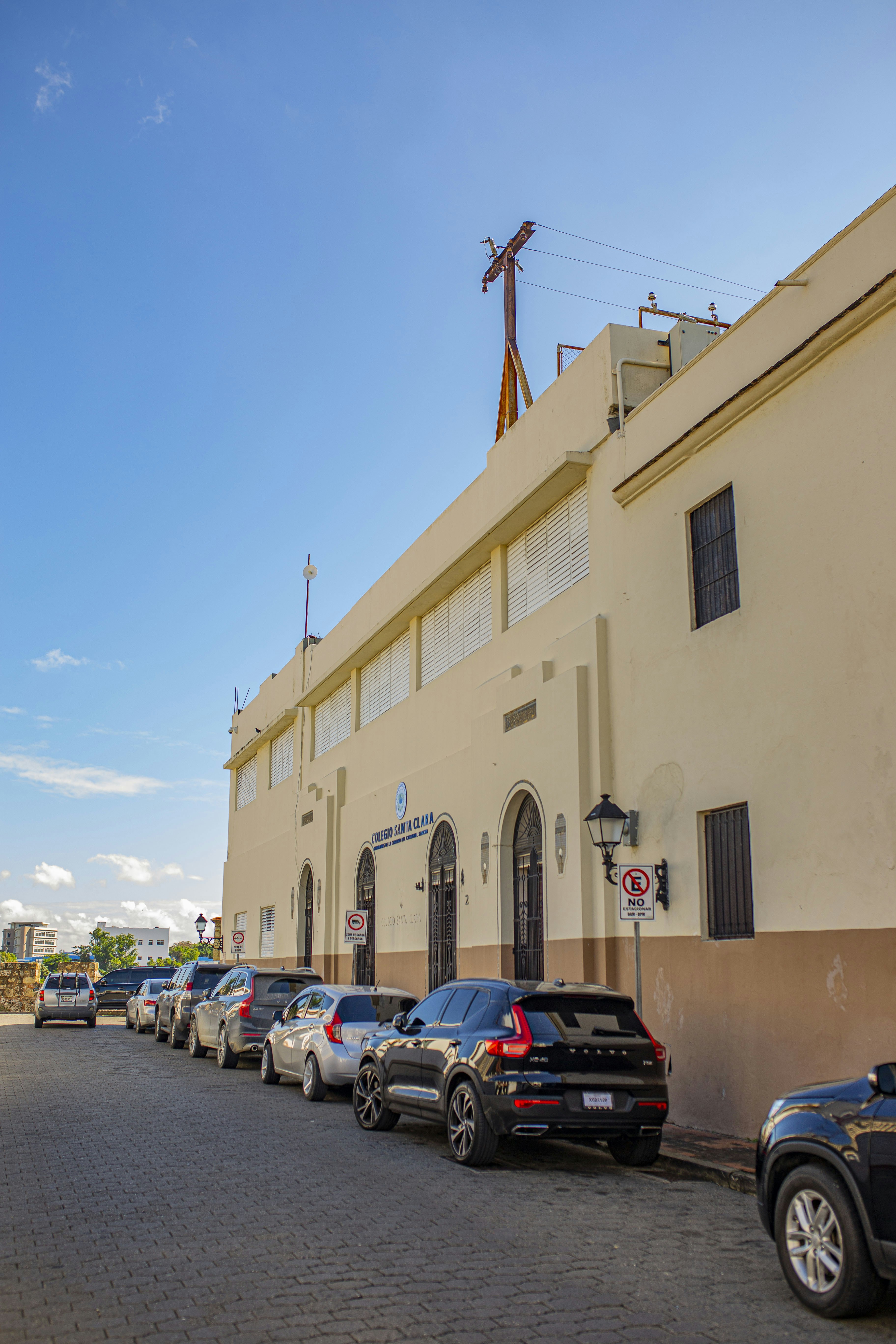 cars parked in front of beige concrete building during daytime