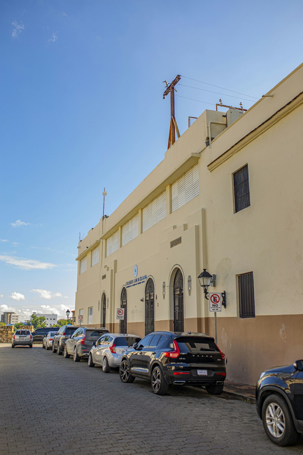 cars parked in front of beige concrete building during daytime