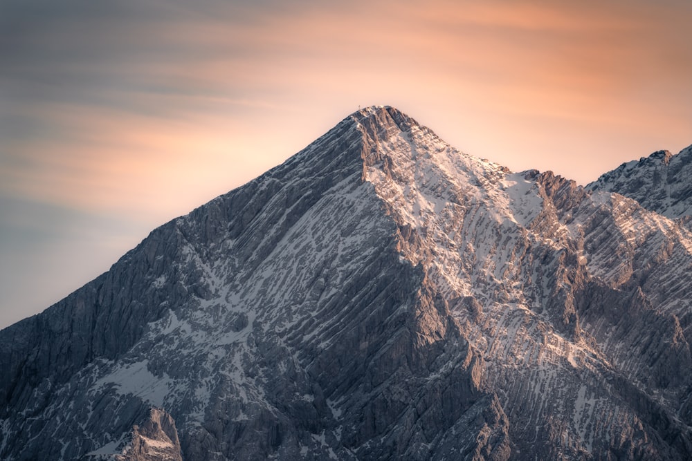 Brauner und grauer Berg unter orangefarbenem Himmel