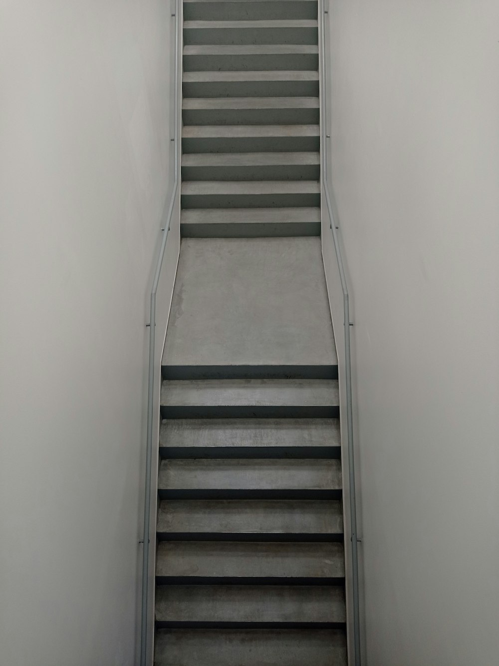 brown wooden staircase beside white wall