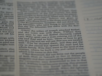 A close-up view of a printed text on a page, possibly from a religious book, focusing on specific verses with a clear column layout. The text appears to be discussing historical events involving tribes.