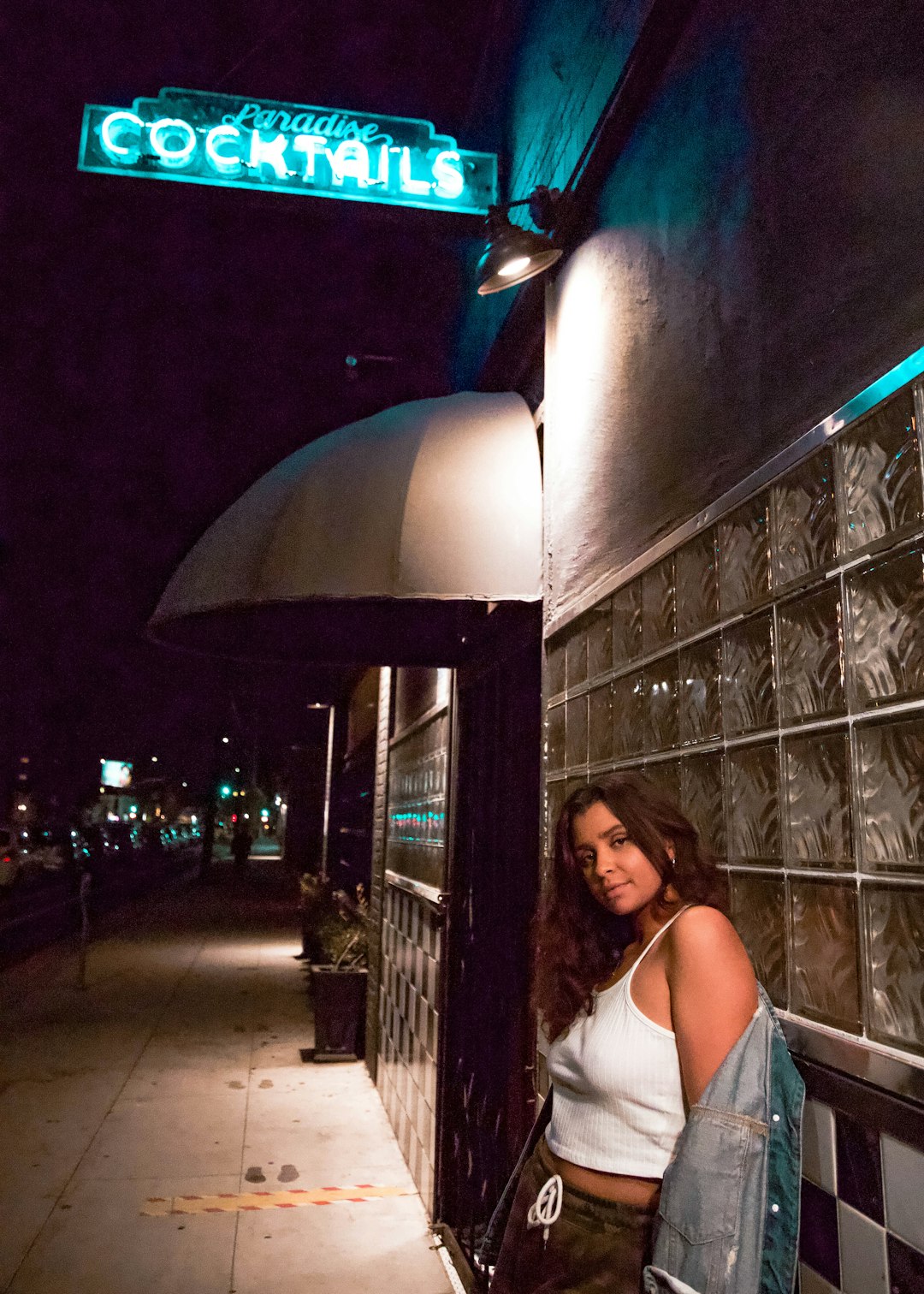 woman in white tank top standing near building during night time