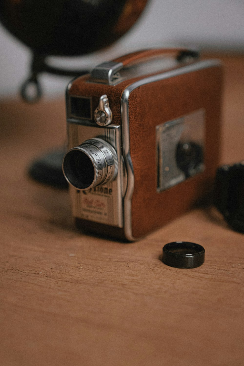 Braune und silberne Kamera auf braunem Holztisch