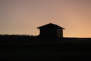 Sunset casting warm golden light over a peaceful barn and surrounding farmland