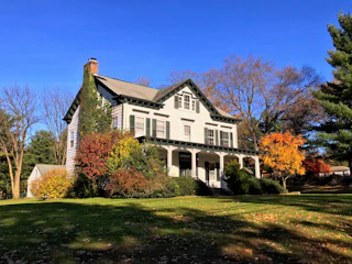 Close-up of freshly installed siding on a charming Clinton Hill home with autumn leaves nearby.