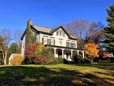 Charming townhouse exterior with white siding and green shutters in Manchester NH.