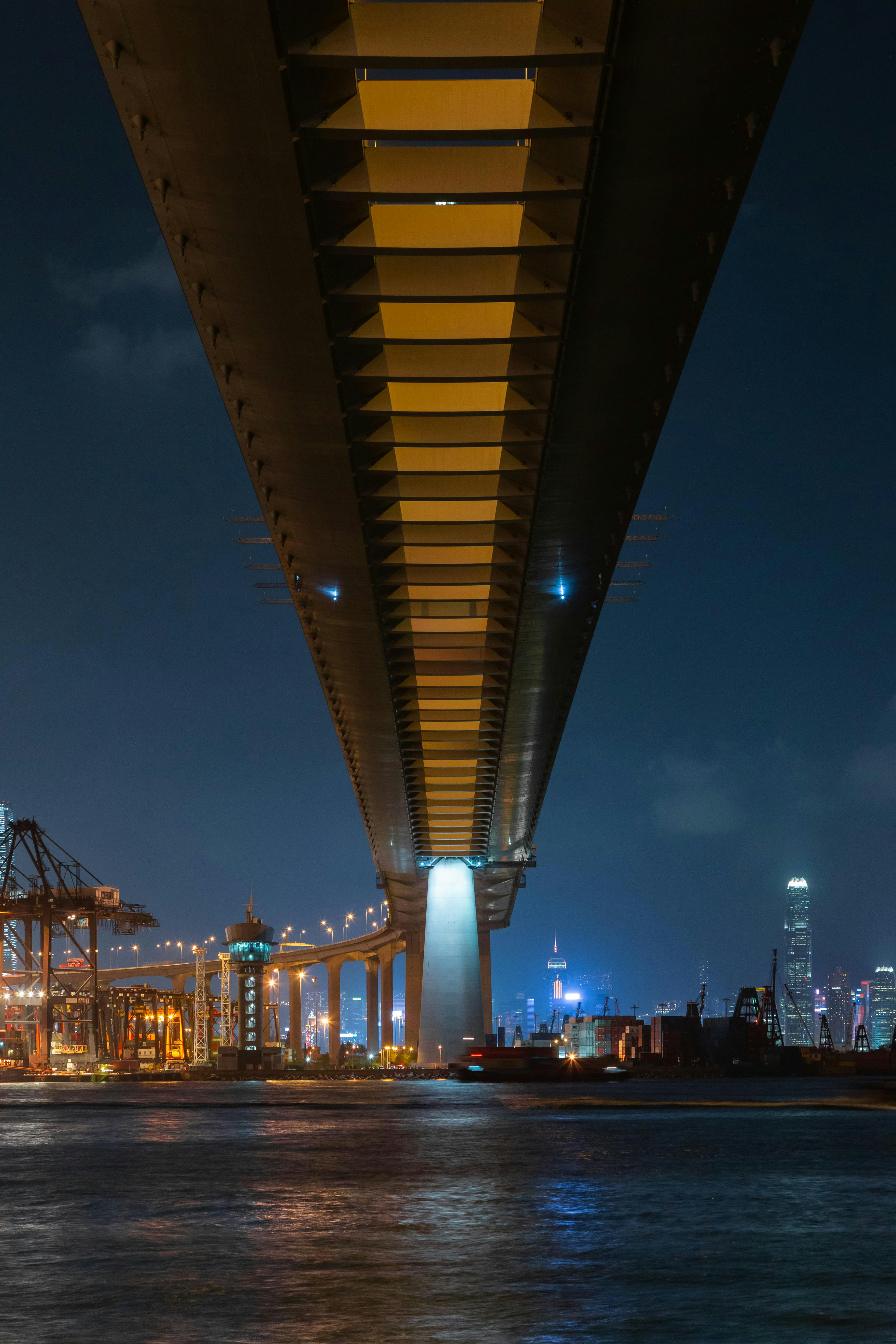 lighted bridge over body of water during night time