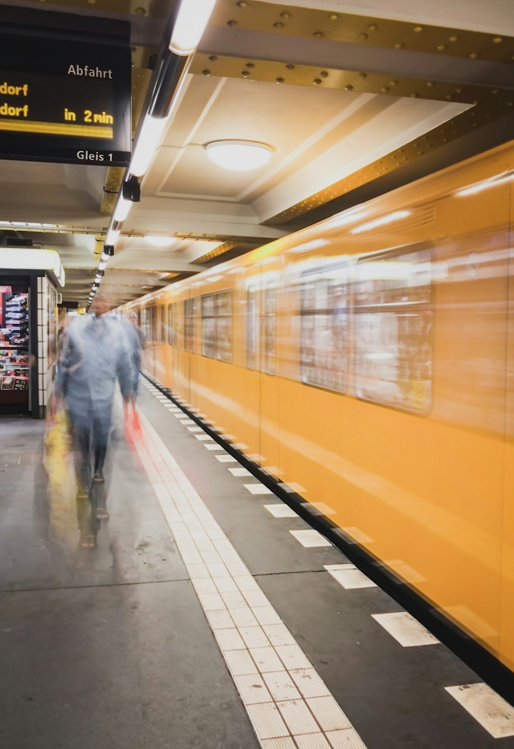 man in gray jacket walking on train station