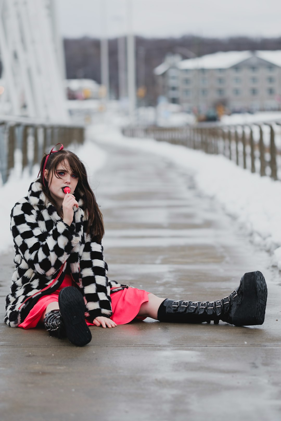 woman in black and white checkered coat sitting on the road