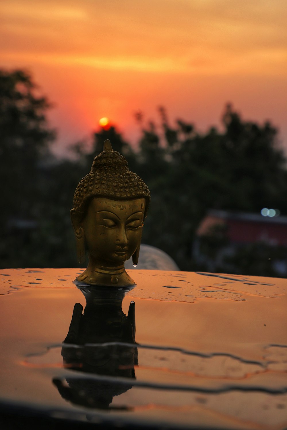 Goldene Buddha-Figur auf weißem Textil bei Sonnenuntergang