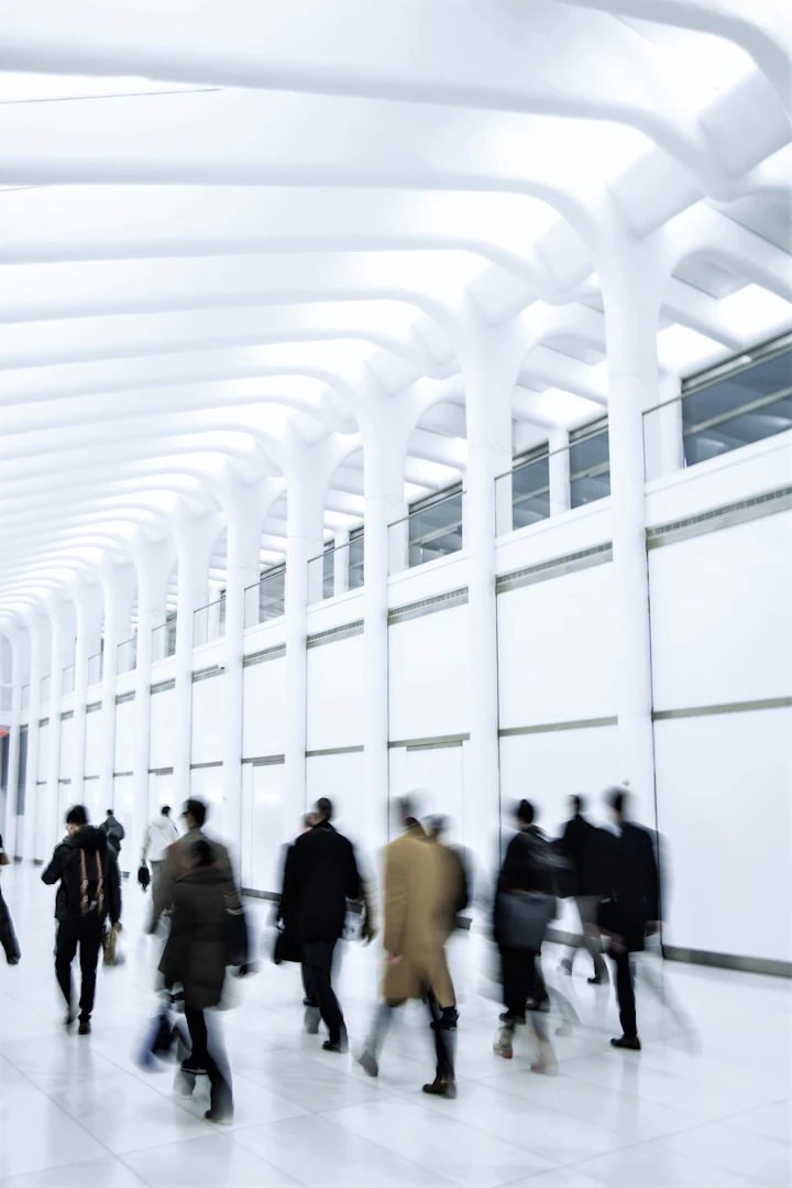 People walking through a white hallway