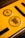A close-up of a yellow vehicle registration plate displaying black symbols and text. The upper section features a circular inspection sticker with numerical markings from 1 to 12 and a highlighted number 10 in the center. Below, a circular emblem contains the text 'Baden-Württemberg' and a stylized coat of arms with lions.