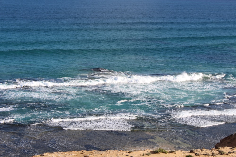 ocean waves crashing on shore during daytime