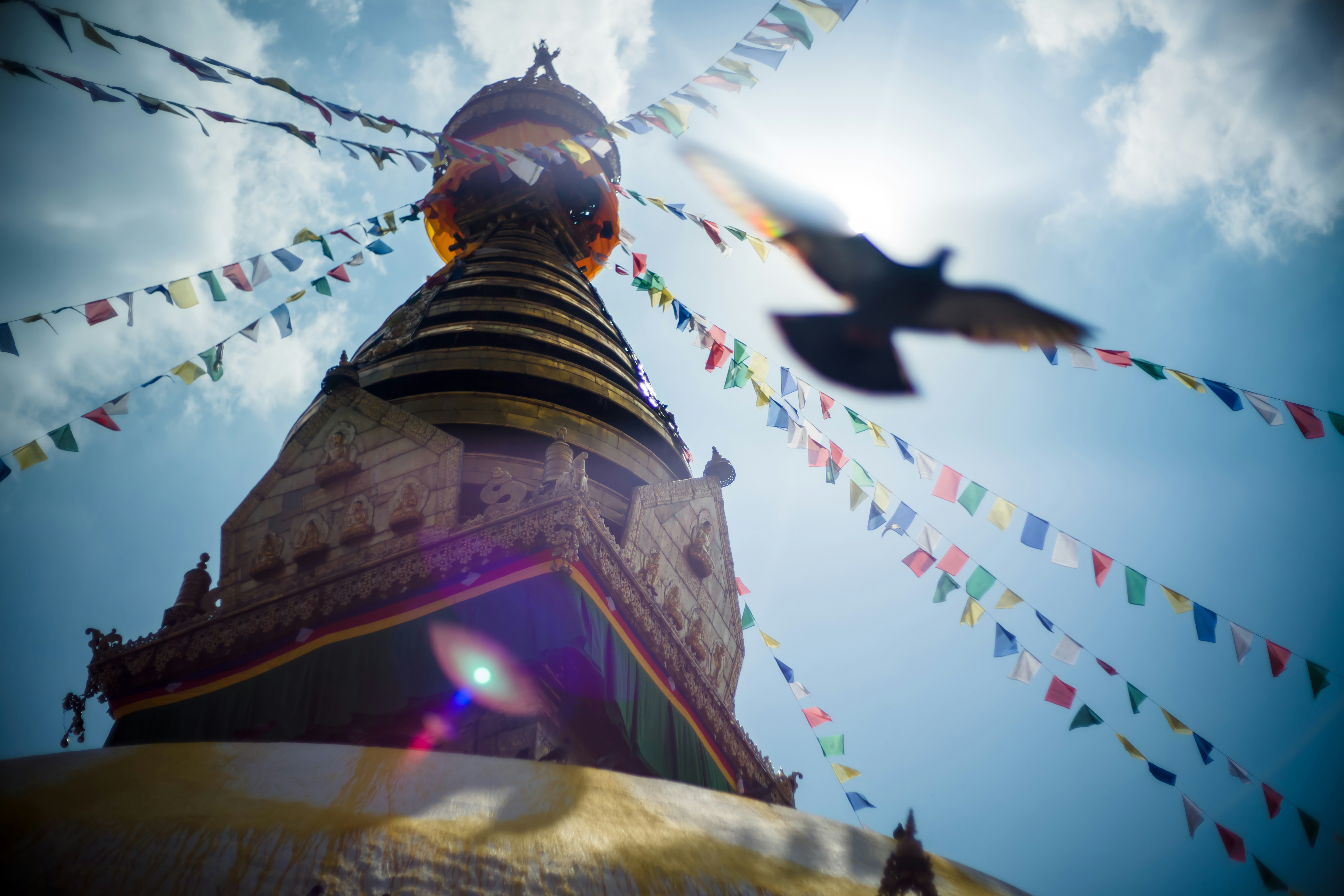 people in a yellow and red temple during daytime, Swayambhunath stupa Eye Buddha in Kathmandu Nepal. Swayambhunath is an ancient religious architecture atop a hill in the Kathmandu Valley, west of Kathmandu city. The Tibetan name for the site means Sublime Trees