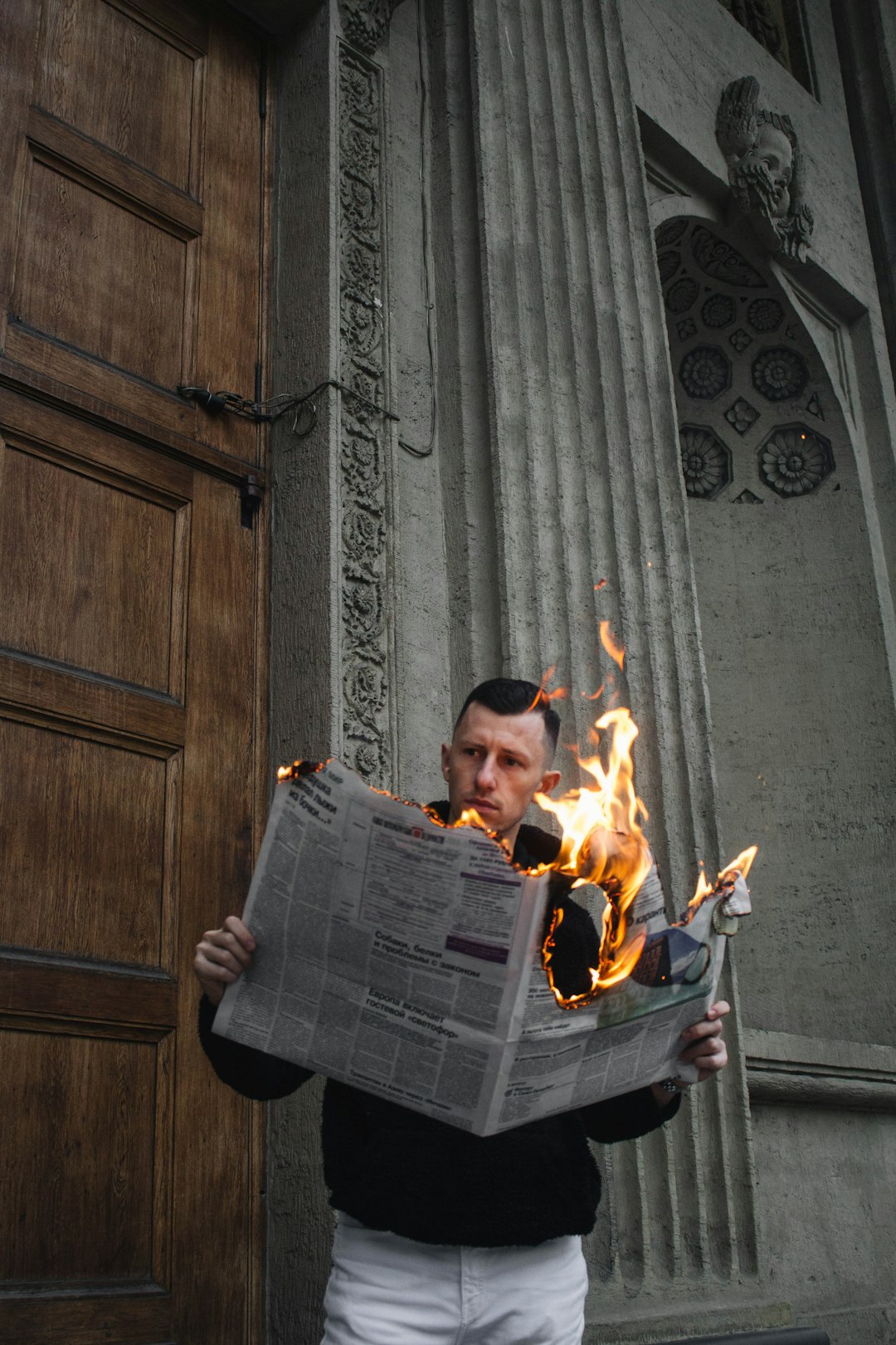 man in black jacket holding newspaper