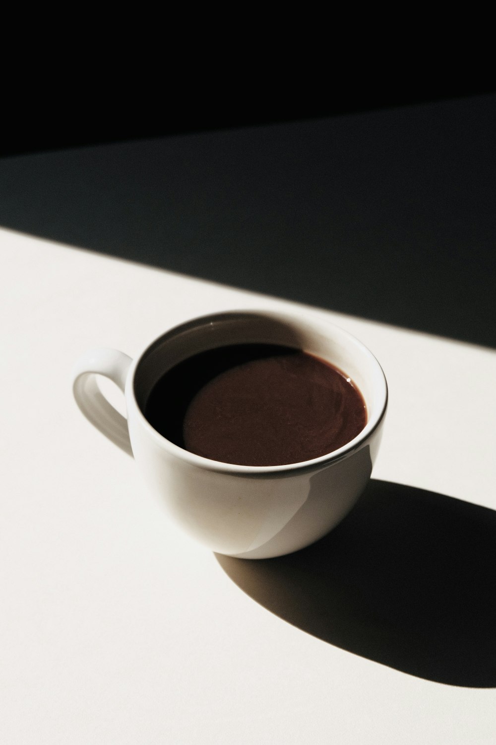 white ceramic mug on white table