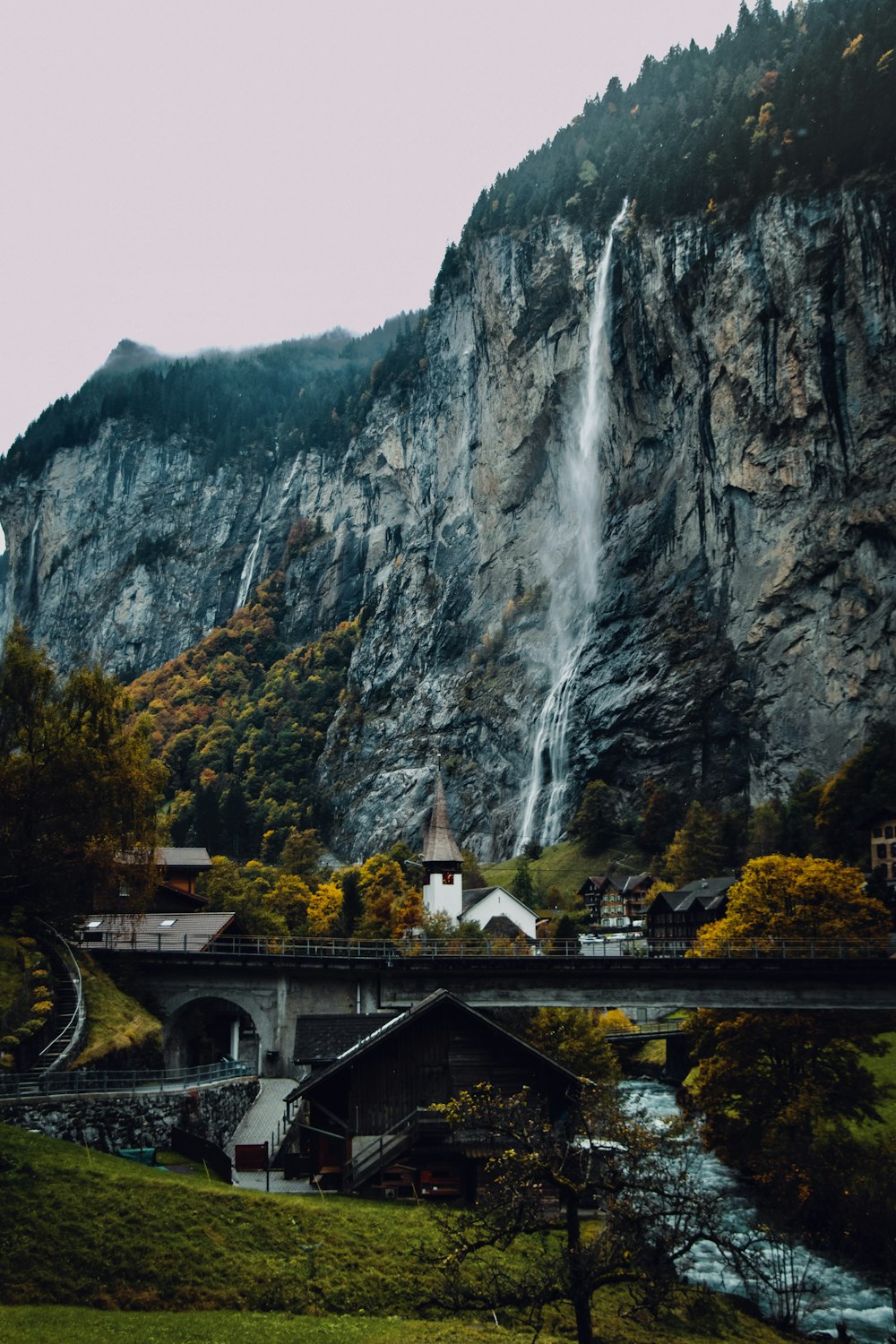 people walking on bridge near waterfalls during daytime