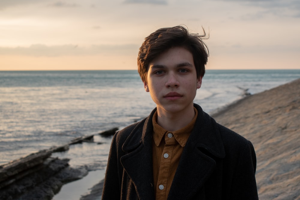 man in black coat standing on beach during daytime