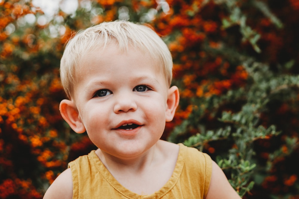 child in yellow tank top smiling