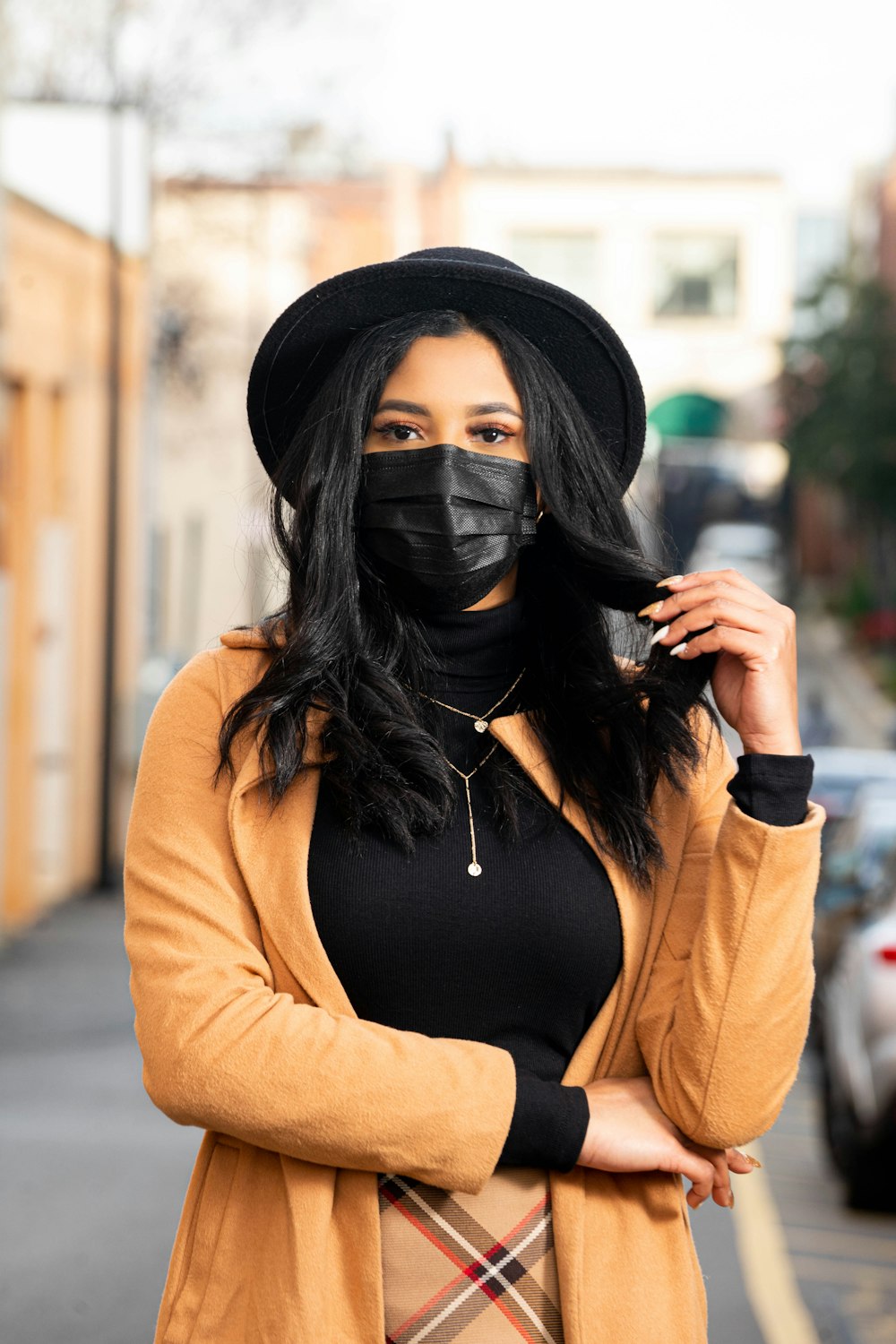 黒髪で顔を覆う茶色の長袖シャツを着た女性
