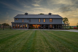 brown and black wooden house on green grass field during daytime