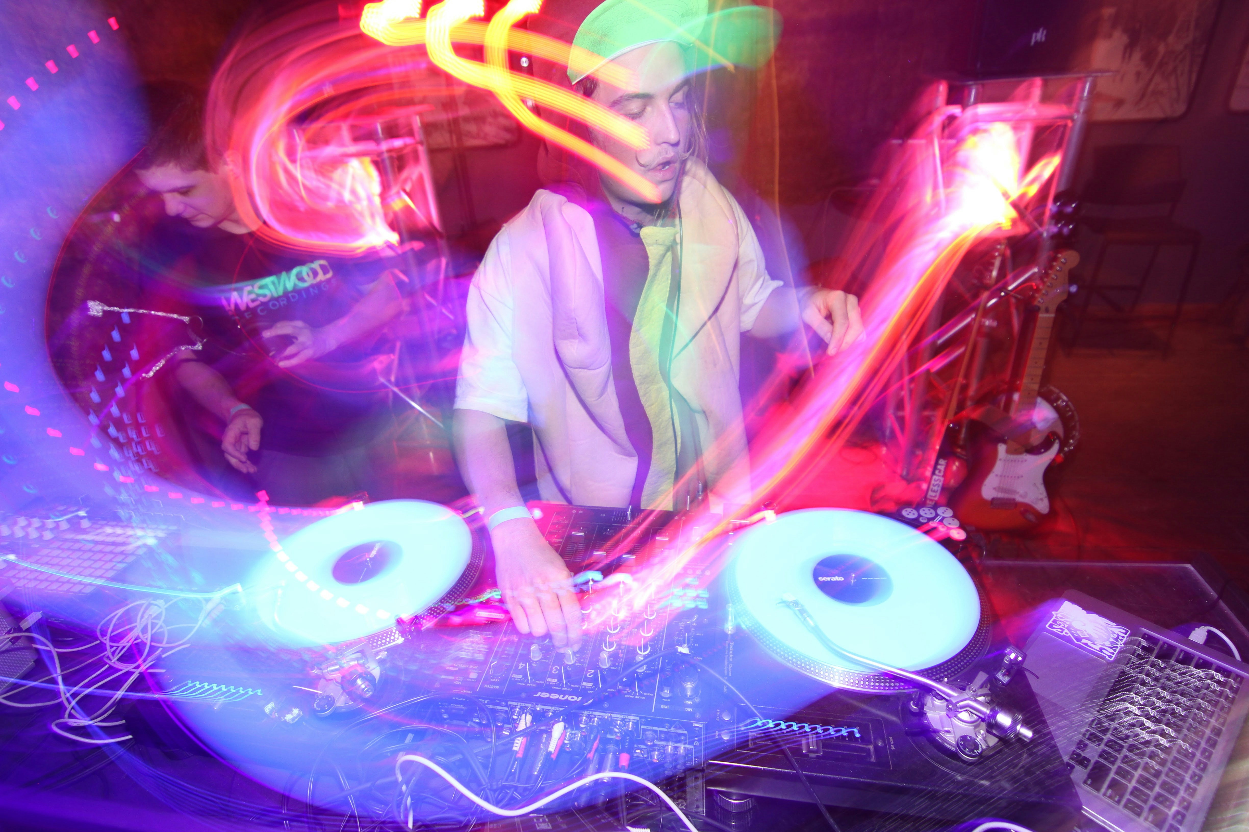 A DJ MIXING BEATS AT A NIGHTCLUB