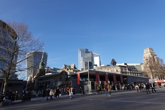 Modern commercial plaza bustling with activity under clear blue skies.