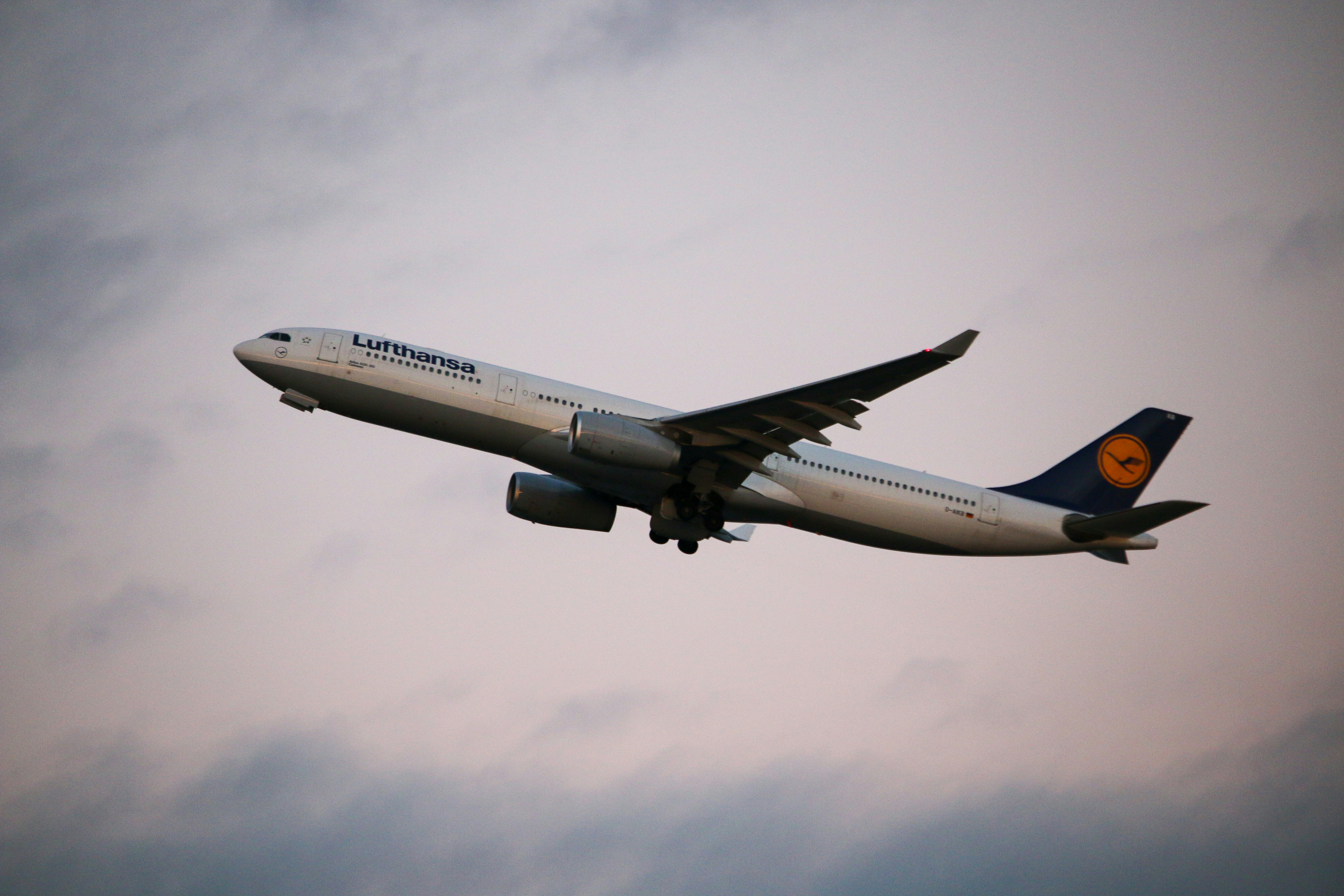 white and blue airplane under white clouds during daytime, A Lufthansa A330 taking off in the sunset from Boston Logan International bound for Frankfurt, Germany. 