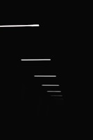 Vertical close-up of thin horizontal lines subtly dividing an off-white background, symbolizing time and space.