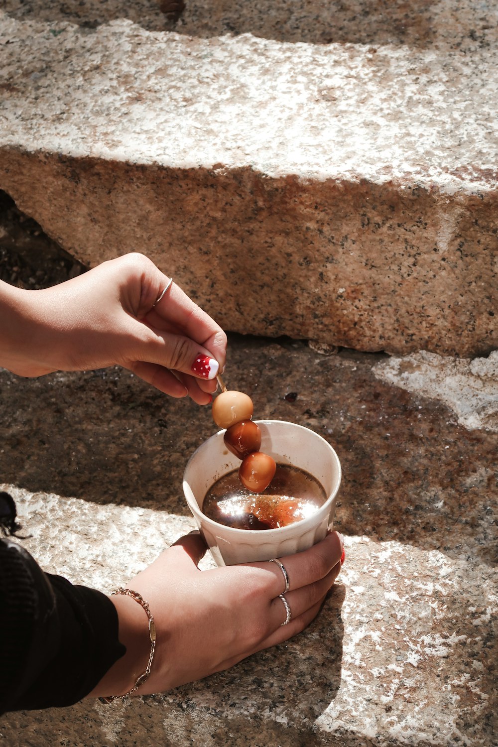 person holding brown egg in stainless steel bowl