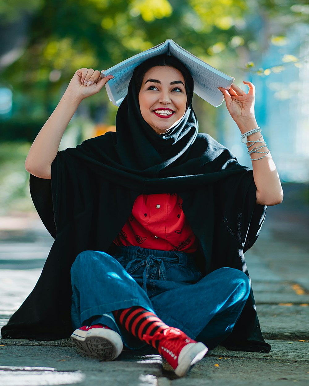 Frau in schwarzem Hijab und rot-weiß gestreiftem Langarmhemd