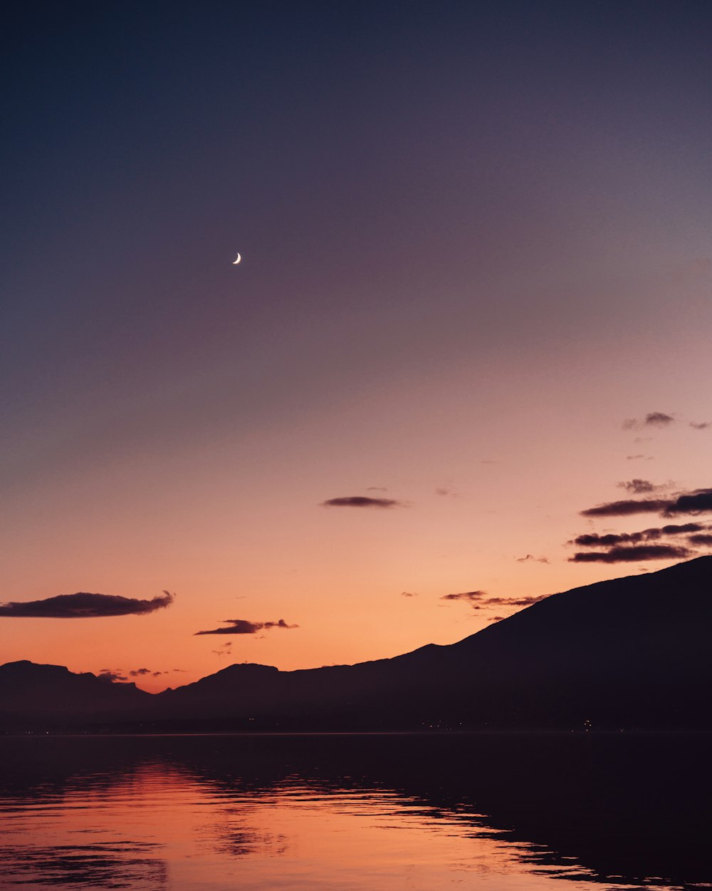 body of water near mountain during daytime