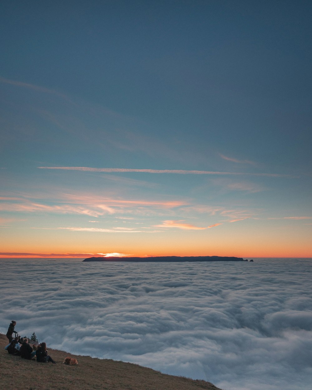 personne assise sur la formation rocheuse pendant le coucher du soleil