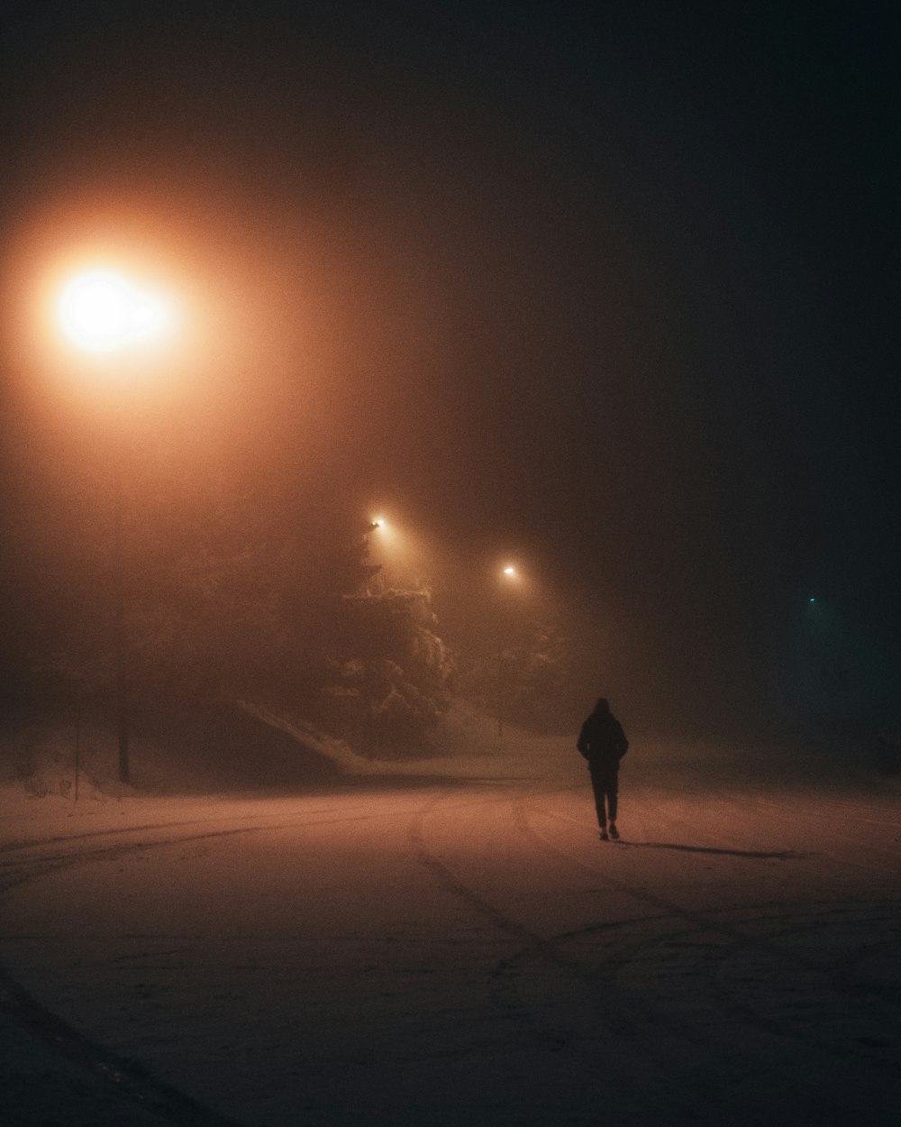 person standing on snow covered ground during night time