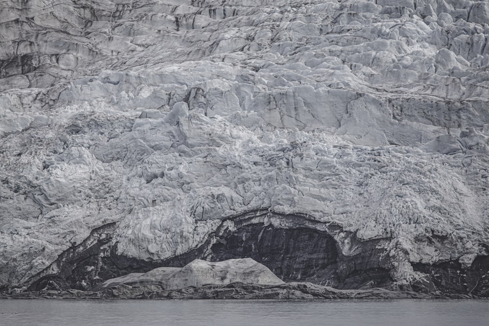 gray rocky mountain beside body of water during daytime