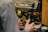 Someone is using a commercial espresso machine to steam milk, holding a stainless steel pitcher under the steam wand.