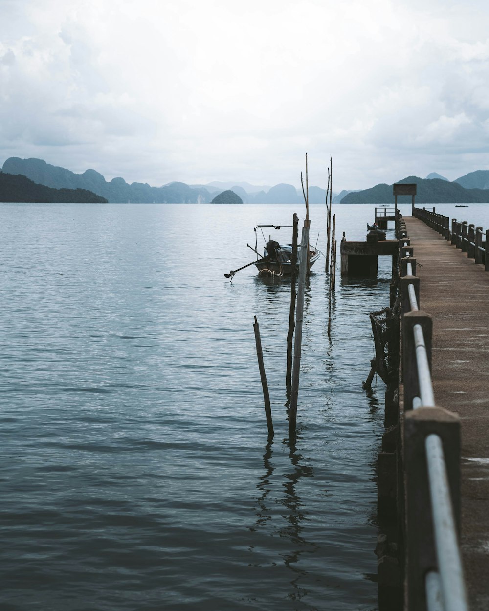 man fishing on sea dock during daytime