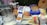 A variety of baking ingredients are arranged on a table, including Quaker Oats, Pillsbury flour, sugar, and a range of other items such as crackers, coconut, and barley. There is also a metal mixing bowl and a plastic ziplock bag containing some powder. Everything is neatly placed and clearly visible.