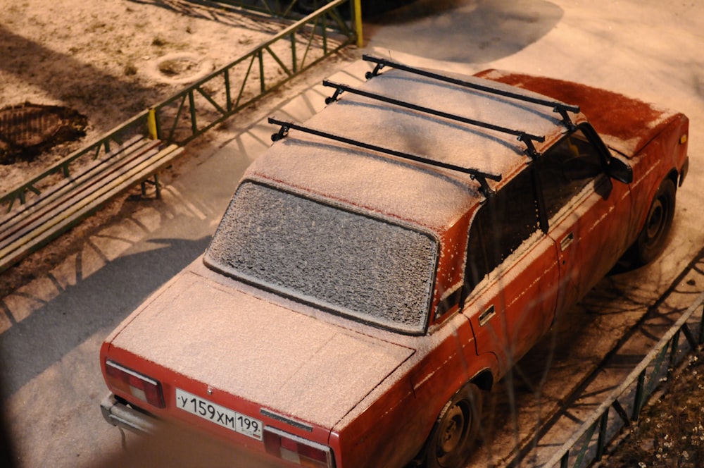 red and white vintage car on gray concrete road during daytime