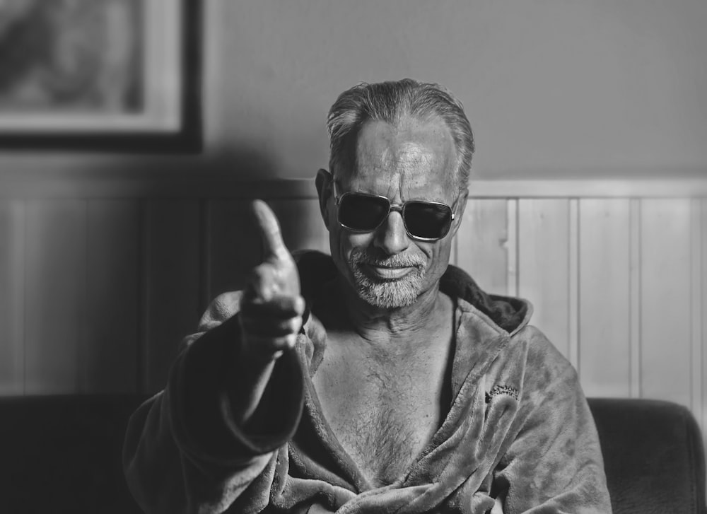 grayscale photo of woman in jacket wearing sunglasses