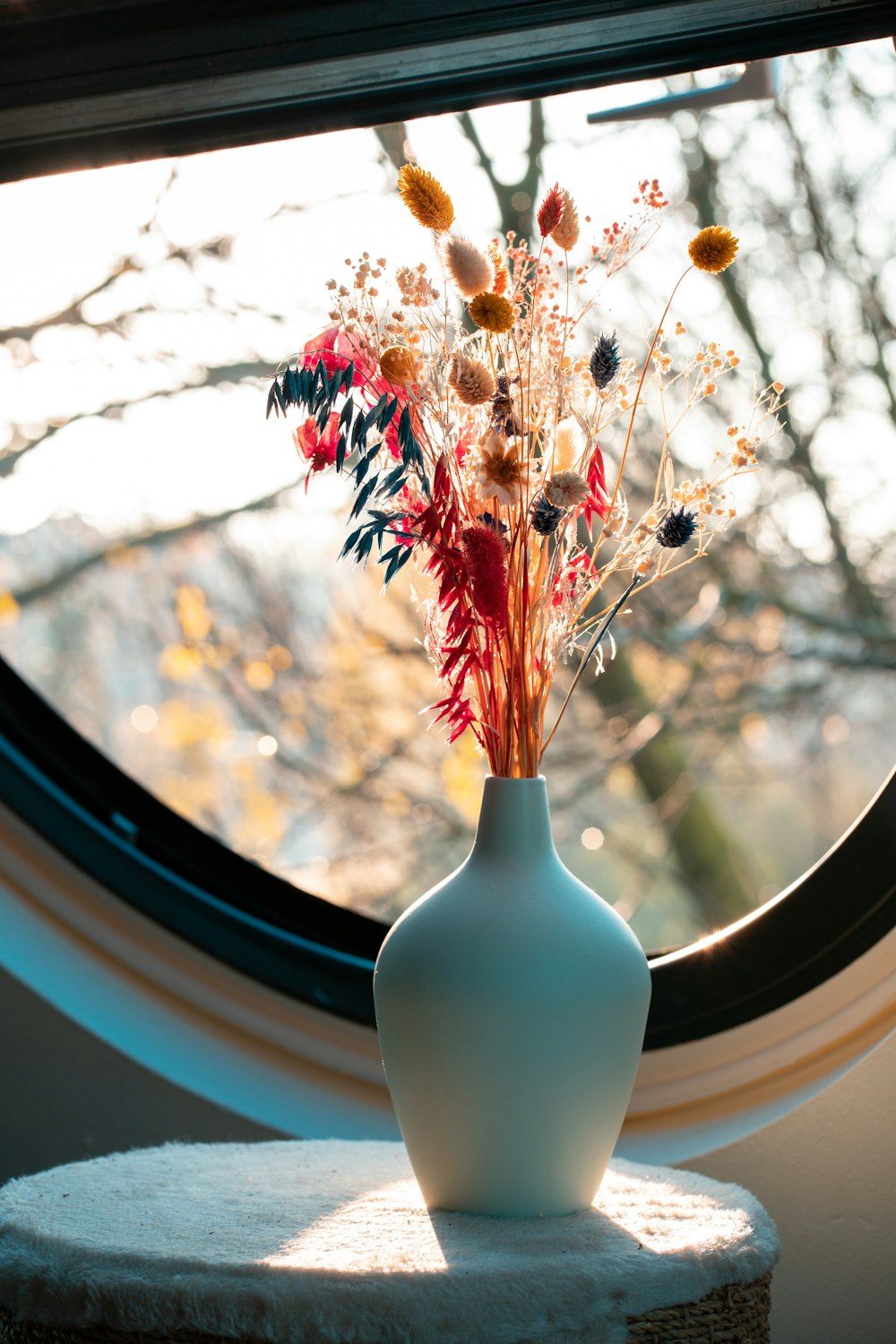 white ceramic vase with orange flowers