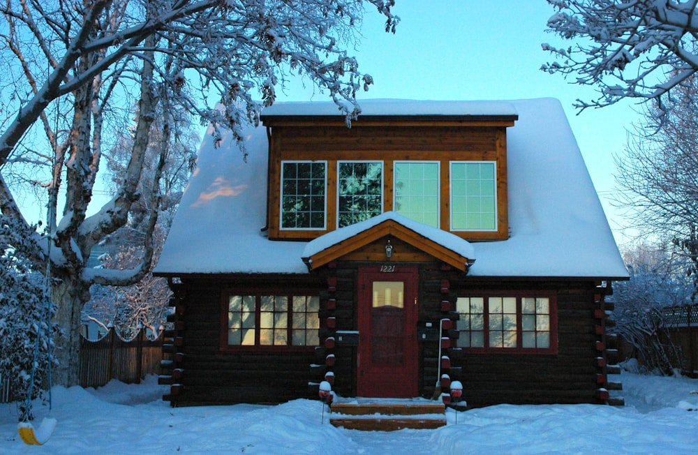 brown wooden house covered with snow during daytime